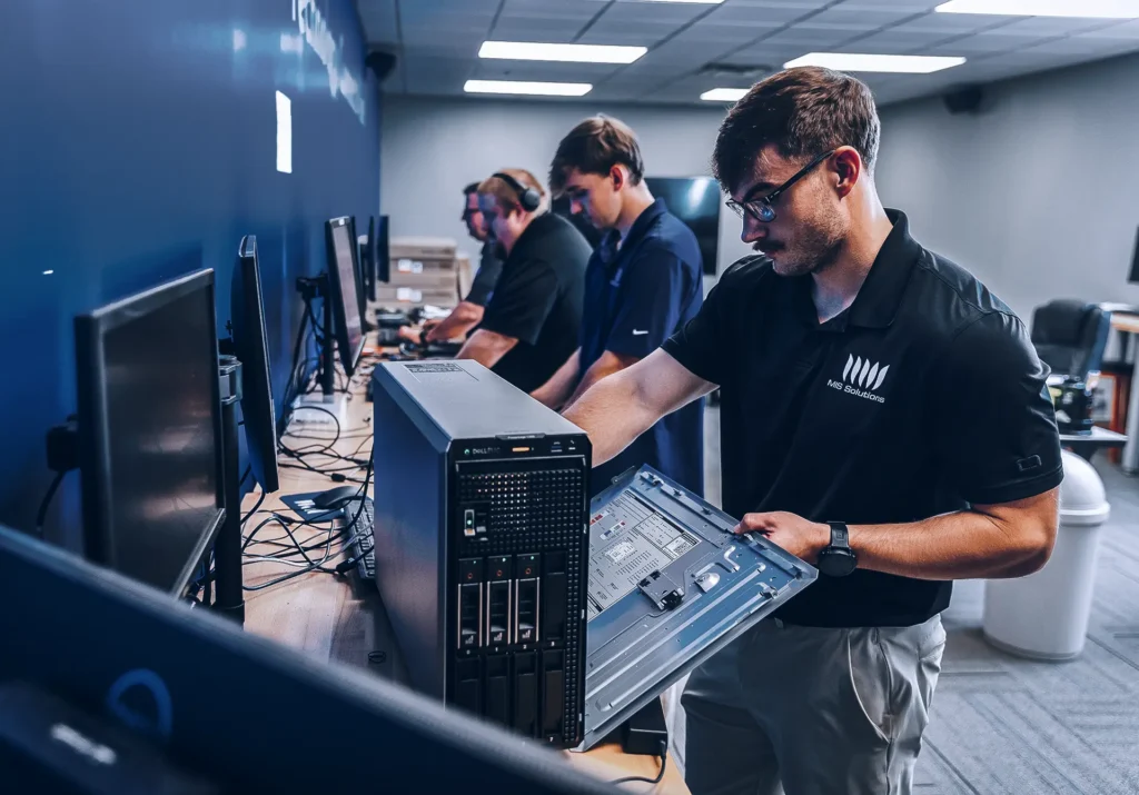 MIS Solutions technician inspecting computer hardware, supporting IT services for non-profits.